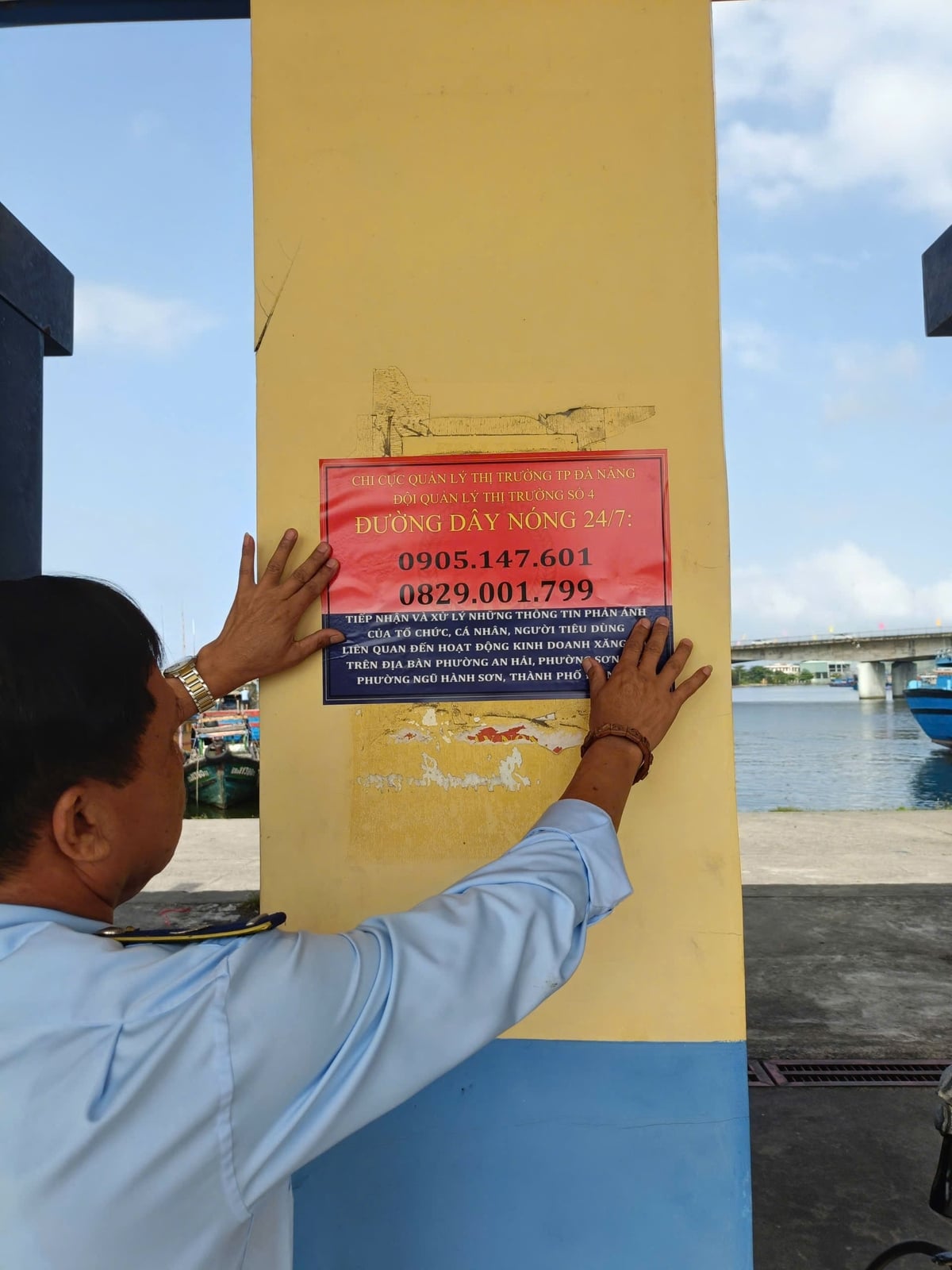 Quản lý thị trường Đà Nẵng hoàn tất dán số điện thoại đường dây nóng tiếp nhận thông tin phản ánh của người dân tại cây xăng. Ảnh: L.A.